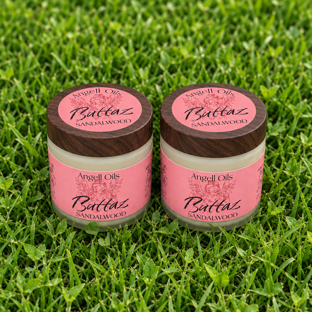 A small jar of Butterz Sandalwood body butter sits on grass. The jar has a pink label and a light wood lid